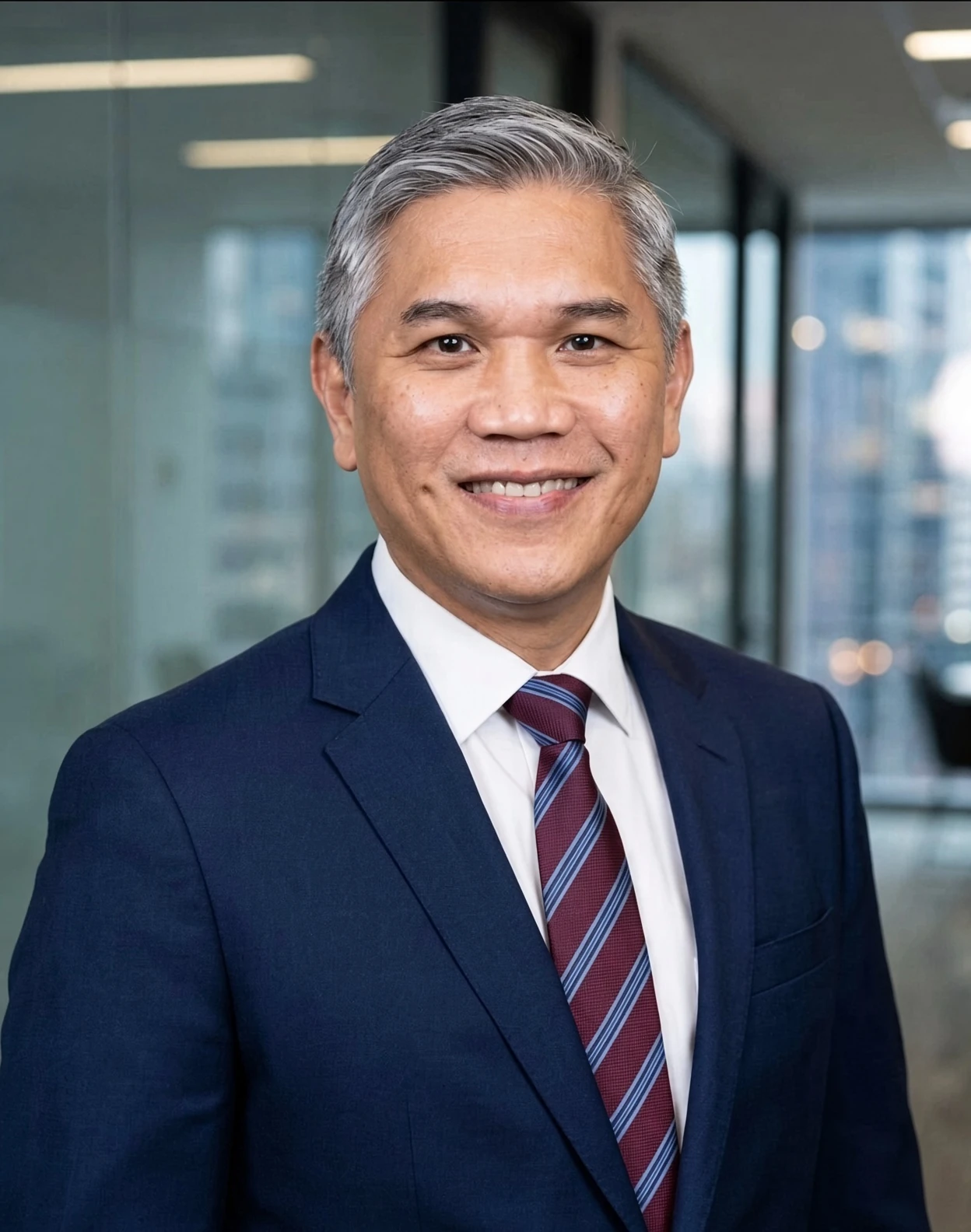 Tan Keat, founder of Kasturi Technology, in a navy suit and striped tie